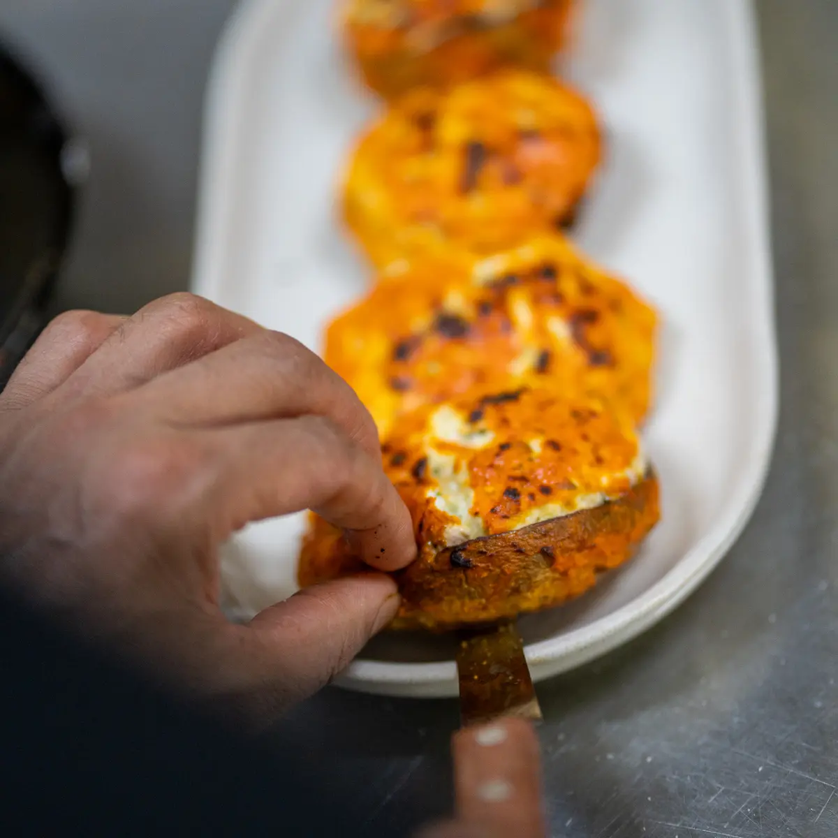Server preparing food with knife.