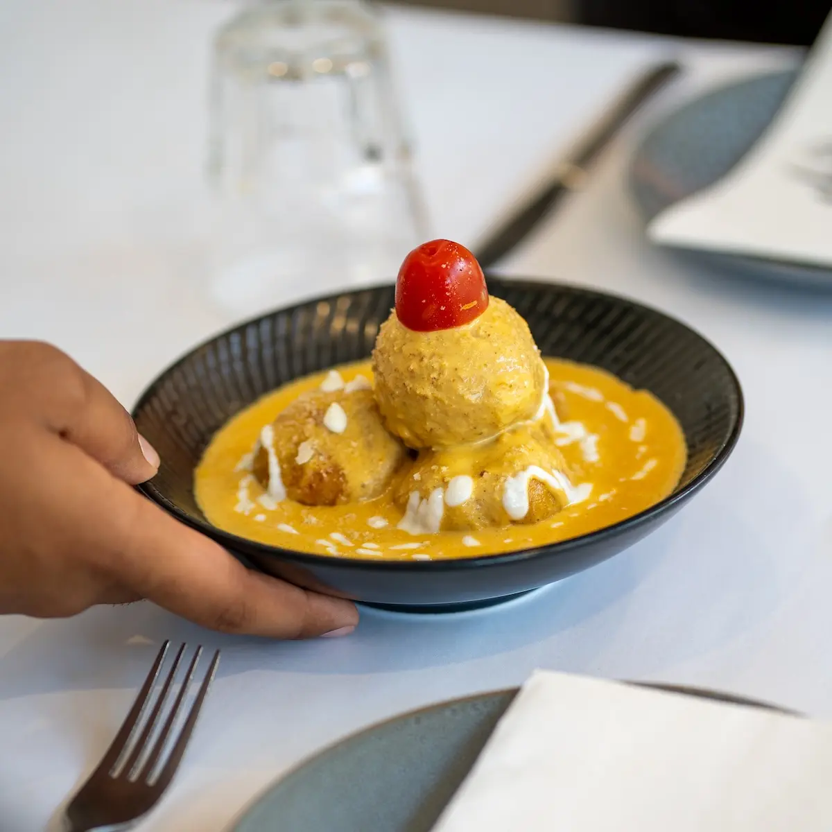 Server serving starter food on table.